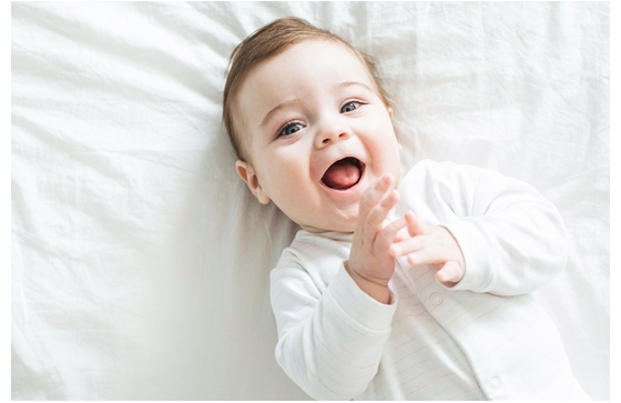 newborn-toddler-boy-laughing-bed (1)